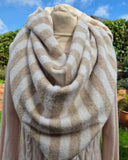 A beige and cream striped fuzzy large triangle scarf
