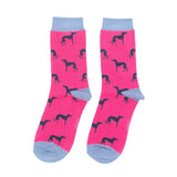 A pair of bright pink crew socks with a repeating black dog silhouette pattern and light blue heels, toes, and ribbed cuffs.