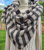 A thick knit infinity scarf with wide black and beige stripes.
